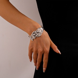 Detailed view of silver irregular wrinkled texture on a wide open cuff bracelet for women
