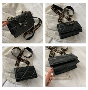 Detail view of black quilted crossbody bag with gold chain and jacquard shoulder strap