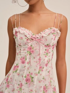 Detail of floral mini dress with pink rose print, ruffle trim and a delicate bow tie