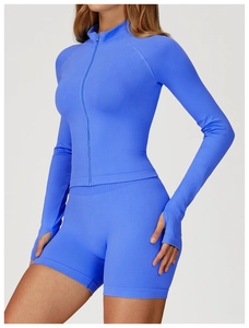 Detail of thumbhole cuffs and seamless knit texture on a blue slim fit yoga jacket