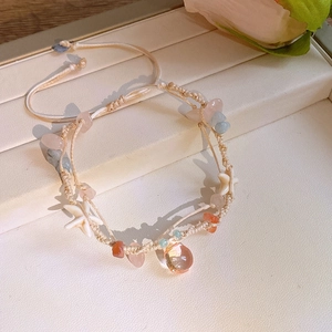 Detail of hand-woven bracelet with colorful crystal chips and a white star charm