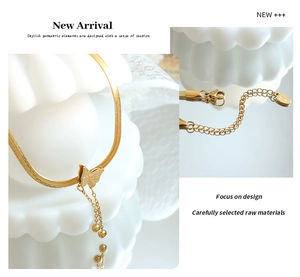 Detailed view of gold butterfly pendant and adjustable lobster clasp on snake chain necklace