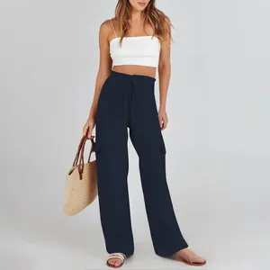 Detailed view of high waist drawstring and cargo pocket on navy wide leg pants