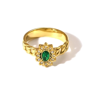 Macro detail of 18K gold curb chain ring band with oval green emerald zircon