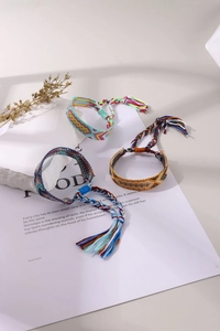 Three colorful handmade Bohemian woven friendship bracelets with geometric patterns and tassels