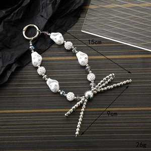 Handmade phone charm with irregular pearls, rhinestone ball and silver metal bow pendant