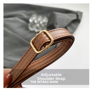 Detailed macro view of adjustable dark brown leather shoulder strap with golden metal buckle