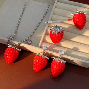 Set gioielli fragola in resina rossa con strass lucidi su espositore in velluto