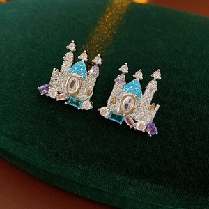 Dettaglio di orecchini a castello in argento con zirconi colorati su velluto verde