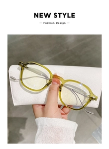 Detail of amber tortoiseshell eyeglasses frame with sleek metal temples on leather case