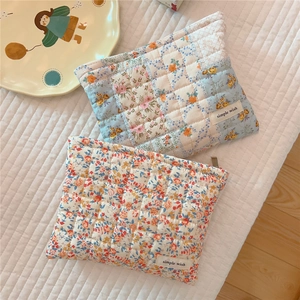 Detail view of floral quilted cotton makeup bag with zipper and soft fabric texture
