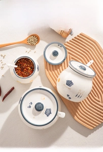 Three-piece ceramic seasoning pot set with lids and spoons featuring blue utensil patterns