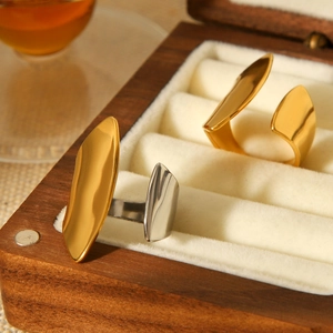 Irregular geometric stainless steel open rings in gold and silver on wooden jewelry box