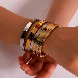 Stackable set of polished stainless steel bracelets in gold and silver finish for women