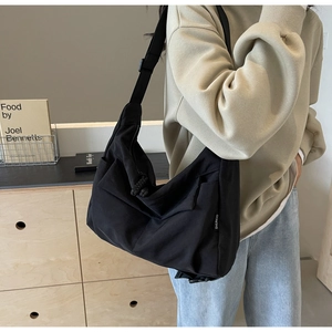 Detailed side view of black large capacity tote bag worn by a model in casual setting
