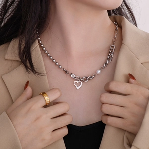 Détail du collier à pendentif cœur argenté avec perles et maille cubaine sur mannequin