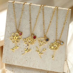 Detail of four 18k gold plated stainless steel birth flower necklaces with colorful gems