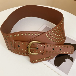 Close-up of vintage brown leather belt featuring antique bronze studs and large horseshoe buckle