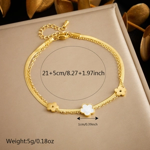 Double-layered gold stainless steel anklet with white shell flowers on a jewelry stand