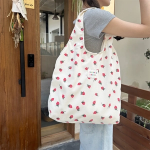 Détail d'un grand sac fourre-tout en velours côtelé blanc avec imprimé fraise rouge