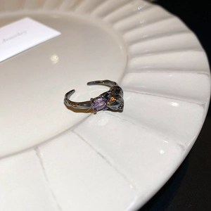 Macro shot of a gunmetal leopard ring with a purple gemstone and textured metal band