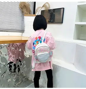 Detail view of kids sequin backpack with heart pocket and pink wings on a young girl