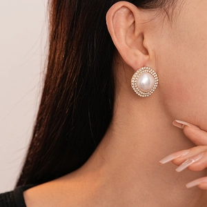 Gros plan de boucles d'oreilles vintage en perles et strass portées par un mannequin