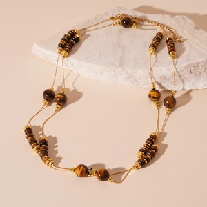 Vintage double layer necklace with gold chain and tiger eye stones on white rock base