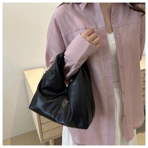 Chic black soft PU leather tote bag shown on model in a minimalist lifestyle setting