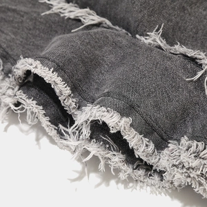 Close-up of raw frayed edges and high-quality twill texture on dark denim bucket hat