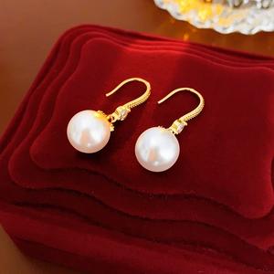 Detail of 14K gold plated earrings with white pearls and sparkling cubic zirconia stones
