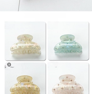 Macro detail of four pastel hair claws with shimmering texture and rhinestones