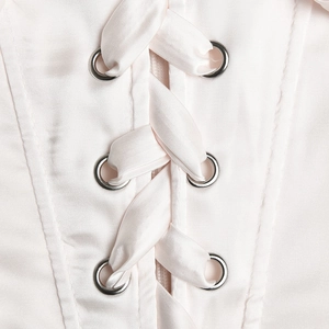 Detail of pink satin dress back featuring lace-up design with metal eyelets and ribbon