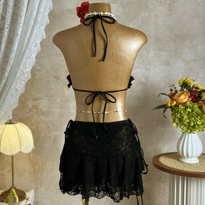 Detail of black crochet lace bikini set with tie-up back and drawstring mesh skirt