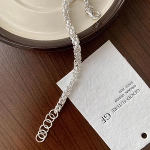 Detailed close-up of woven S925 sterling silver chain bracelet with lobster clasp