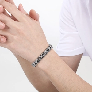 Close-up of a silver polished curb chain bracelet worn on a wrist with minimalist design