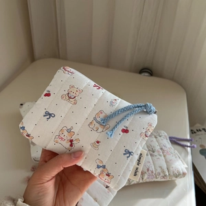 Close-up of quilted cotton coin purse with cute cartoon bear and cat patterns