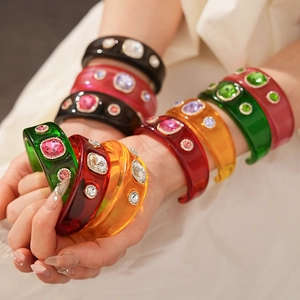 Close-up of vintage resin bangles with colorful rhinestones on a wrist
