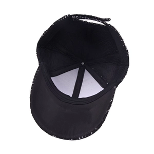 Inside view of a black and white tweed baseball cap showing inner lining and stitching