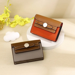 Detail of two-tone lychee pattern leather card holders with round metal buckle