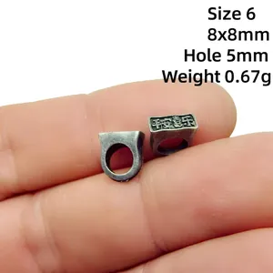 Macro shot of 8x8mm antique alloy bead with Ping An Xi Le engraving and 5mm hole