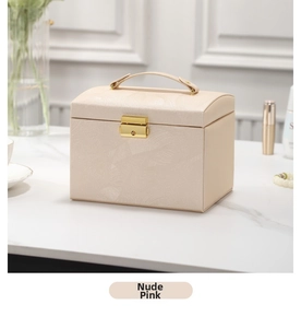 Detail of nude pink PU leather jewelry box with golden lock and top handle