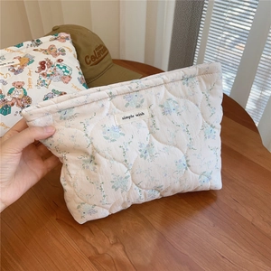 Close-up of heart-shaped quilted cotton makeup bag with floral patterns and zipper