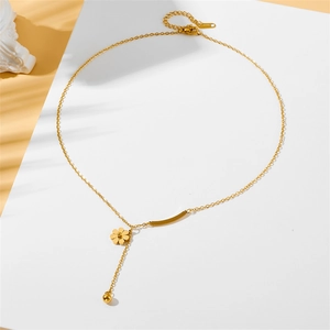 Macro d'un collier marguerite en acier inoxydable doré avec pendentif floral poli