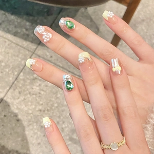 Hand-painted bow pearl press-on nails with green teardrop rhinestones and yellow accents