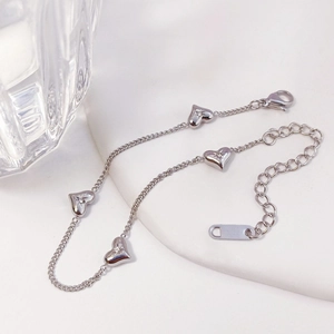 Detail of silver heart bracelet with starburst engraving and sparkling crystal accents