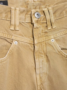 Detailansicht der gelben Twill-Jeans mit Metallknopf, Nieten und hochdichten Nähten
