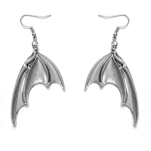Détail macro de boucles d'oreilles ailes de chauve-souris gothiques en métal argenté