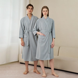Light gray waffle knit hotel bathrobe for men and women with white contrast piping details