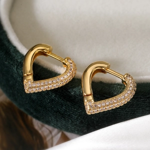 Exquisite gold-plated heart hoop earrings with sparkling cubic zirconia on green velvet